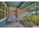 Cozy front porch featuring a charming swing, brick accents, and lush landscaping at 2551 Cross Country Dr, Port Orange, FL 32128