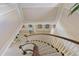 Elegant, curved staircase featuring white spindles, a wooden handrail, and neutral carpet for a luxurious feel at 2551 Cross Country Dr, Port Orange, FL 32128