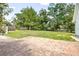 Expansive backyard with brick patio, green grass, mature trees, and privacy fence at 257 Huntington Dr, Deland, FL 32724