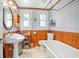 A bright bathroom features a pedestal sink, a freestanding tub, and stylish wood accents at 257 Huntington Dr, Deland, FL 32724