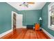 A charming bedroom featuring gleaming hardwood floors, unique lighting fixtures, and tasteful decor at 257 Huntington Dr, Deland, FL 32724