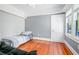 A bedroom featuring hardwood floors, a twin bed, and natural light streaming through the large window at 257 Huntington Dr, Deland, FL 32724