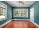 A spacious bedroom with gleaming hardwood floors and bright natural light from a large window at 257 Huntington Dr, Deland, FL 32724