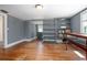 Neutral-toned bedroom with hardwood floors and shelving unit with an open doorway at 257 Huntington Dr, Deland, FL 32724