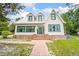 Charming two-story home with a brick pathway and lovely green accents on the windows and front door at 257 Huntington Dr, Deland, FL 32724