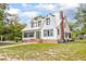 Beautiful two-story home featuring a white exterior, metal roof, brick foundation, and verdant window trim at 257 Huntington Dr, Deland, FL 32724
