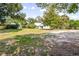 Spacious front yard with a charming white home, mature trees, and a long driveway at 257 Huntington Dr, Deland, FL 32724