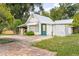 Garage with a metal roof, green door and mature green landscaping around the house at 257 Huntington Dr, Deland, FL 32724
