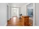 Hallway featuring wood floors, sun-filled alcove with a classic table and an open doorway at 257 Huntington Dr, Deland, FL 32724