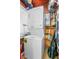 A laundry room area with a stacked washer and dryer, shelving, and wire racks at 257 Huntington Dr, Deland, FL 32724