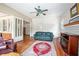 Cozy living room featuring hardwood floors, classic ceiling fan, fireplace, and open doorway at 257 Huntington Dr, Deland, FL 32724