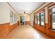 Bright living room with wood-paneled walls, beautiful wood trim, hardwood floors, and multiple windows at 257 Huntington Dr, Deland, FL 32724