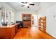 Home office featuring hardwood floors, natural light, built-in shelving and cabinets, and an adjacent room at 257 Huntington Dr, Deland, FL 32724