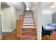 Wooden staircase with carpet runners, blending classic design with a touch of color at 257 Huntington Dr, Deland, FL 32724