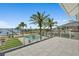 Outdoor view of pool, waterfront and dock framed by white fencing and palm trees at 2636 S Peninsula Dr, Daytona Beach, FL 32118