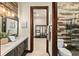 Elegant bathroom featuring a modern vanity, wood accent wall, and a glass-enclosed shower with tile design at 2636 S Peninsula Dr, Daytona Beach, FL 32118
