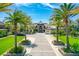 Well-manicured home featuring a brick driveway lined with mature palm trees and lush landscaping at 2636 S Peninsula Dr, Daytona Beach, FL 32118