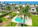 Backyard oasis with a sparkling pool, lush landscaping, mature palm trees, and sunny skies at 2636 S Peninsula Dr, Daytona Beach, FL 32118