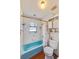 Compact bathroom with a blue bathtub and a neutral color scheme at 2704 Burgoyne Pl, Deland, FL 32720