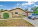 Single-story home featuring stone accents, a red front door, and well-maintained landscaping at 2704 Burgoyne Pl, Deland, FL 32720