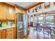 Charming kitchen with wood cabinetry, stainless steel refrigerator, and open dining area at 2704 Burgoyne Pl, Deland, FL 32720