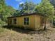 Exterior of home featuring boarded window and overgrown landscape at 288 Mcmillon Dr, Orange City, FL 32763