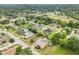 Aerial shot showcasing a yellow home with solar panels and a screened pool in a residential community at 2940 Se 23Rd Ave, Ocala, FL 34471