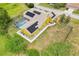 A yellow single-Gathering home with solar panels and screened pool is featured in an aerial view of the backyard at 2940 Se 23Rd Ave, Ocala, FL 34471