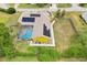 A yellow single-Gathering home with solar panels and screened pool is featured in an aerial view at 2940 Se 23Rd Ave, Ocala, FL 34471