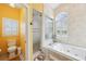 Bright, tiled bathroom featuring a glass door shower, jacuzzi tub, and shuttered windows at 2940 Se 23Rd Ave, Ocala, FL 34471