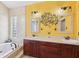 Bright bathroom featuring a dual sink vanity, decorative wall art, and a soaking tub at 2940 Se 23Rd Ave, Ocala, FL 34471