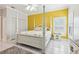 Bedroom with white 4-poster bed, tile flooring, yellow accent wall, and shuttered windows at 2940 Se 23Rd Ave, Ocala, FL 34471