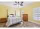 Bedroom with a yellow accent wall, tile floors, and a four-poster bed with shutters at 2940 Se 23Rd Ave, Ocala, FL 34471