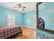 Blue bedroom with wood-look floors, two shuttered windows, ceiling fan and a mirror at 2940 Se 23Rd Ave, Ocala, FL 34471