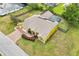 A yellow single-Gathering home features a brick driveway, a two-car garage, and well-maintained landscaping in this aerial view at 2940 Se 23Rd Ave, Ocala, FL 34471