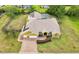 Aerial view of a yellow single-Gathering home featuring a brick driveway, a two-car garage, and well-maintained landscaping at 2940 Se 23Rd Ave, Ocala, FL 34471