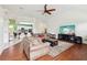 Open-concept living room with wood floors, a large TV, and view to kitchen at 2940 Se 23Rd Ave, Ocala, FL 34471