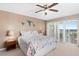 Bright bedroom featuring a king-size bed, ceiling fan, and sliding glass doors to a balcony with a view at 2967 S Atlantic Ave # 1601, Daytona Beach Shores, FL 32118