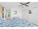 Comfortable bedroom with a ceiling fan, blue floral comforter, and access to an adjacent room, creating a relaxing space at 2967 S Atlantic Ave # 1601, Daytona Beach Shores, FL 32118