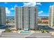 An aerial view of the building featuring a refreshing pool surrounded by well-maintained landscaping at 2967 S Atlantic Ave # 1601, Daytona Beach Shores, FL 32118