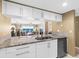 Bright kitchen with white cabinets, granite countertops, stainless steel appliances, and a view into the dining and living room at 2967 S Atlantic Ave # 1601, Daytona Beach Shores, FL 32118