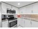 Stylish kitchen featuring stainless steel appliances, granite countertops, and white cabinets, creating a modern cooking space at 2967 S Atlantic Ave # 1601, Daytona Beach Shores, FL 32118