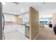 Bright kitchen with white cabinets, stainless steel appliances, granite countertops, and a view into the living room at 2967 S Atlantic Ave # 1601, Daytona Beach Shores, FL 32118