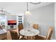 Cozy dining area with a marble table, four chairs, and a ceiling light fixture near the window at 3023 S Atlantic Ave # 4020, Daytona Beach, FL 32118