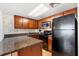 Compact kitchen featuring granite countertops, wooden cabinets, and modern appliances at 3023 S Atlantic Ave # 4020, Daytona Beach, FL 32118