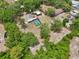 Aerial view of property with mature trees and a screened in pool, surrounded by lush greenery at 31544 Wekiva River Trl, Sorrento, FL 32776