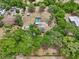 An overhead shot shows a home and pool surrounded by mature trees at 31544 Wekiva River Trl, Sorrento, FL 32776