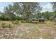 A large backyard with mature trees and landscaping, and the exterior of the house at 31544 Wekiva River Trl, Sorrento, FL 32776