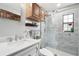 Bathroom with updated white tile shower, white vanity and wooden cabinets at 31544 Wekiva River Trl, Sorrento, FL 32776