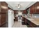 Functional kitchen with plentiful dark wood cabinets, stainless steel appliances, and a ceiling fan at 31544 Wekiva River Trl, Sorrento, FL 32776